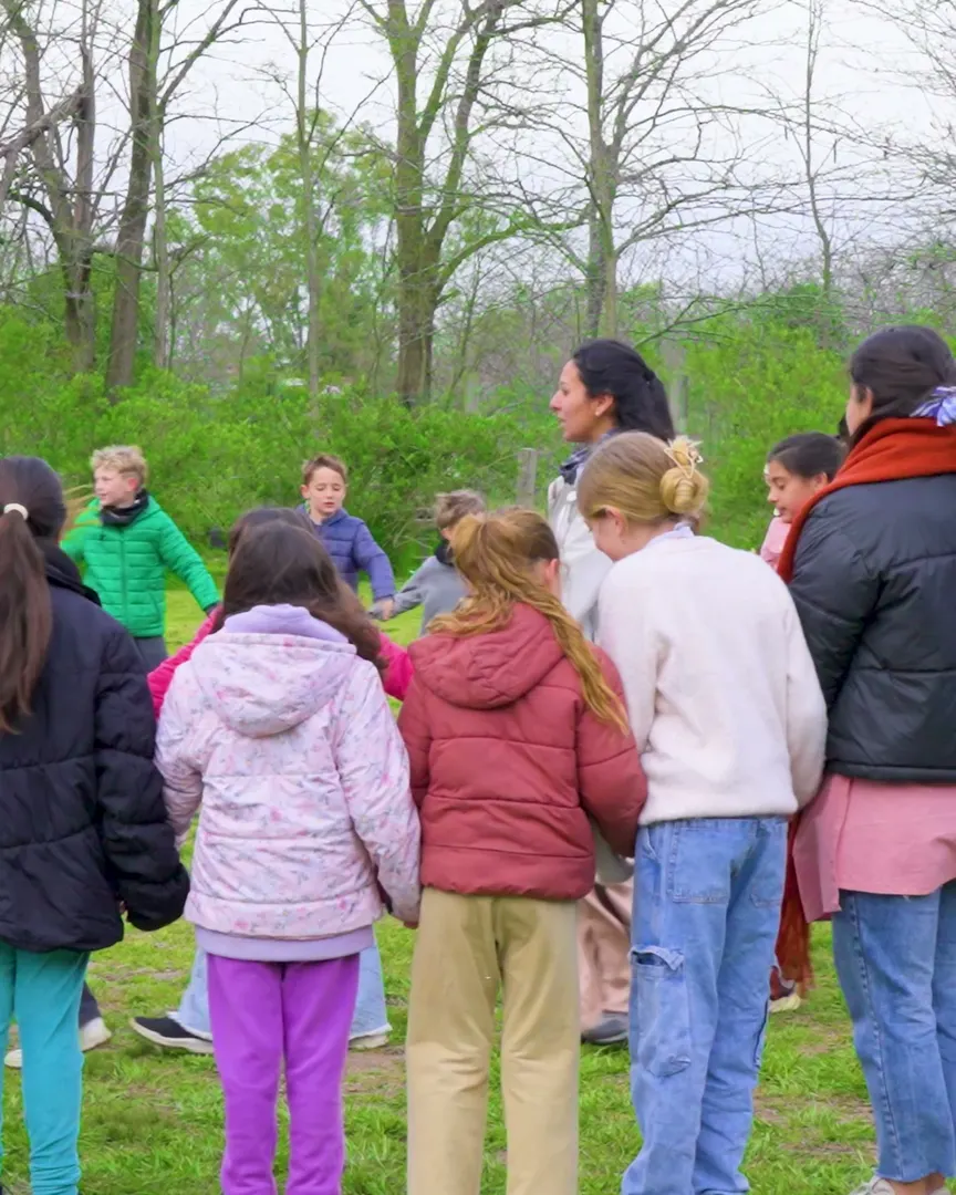 Alumnos y maestras en ronda en el parque de la escuela